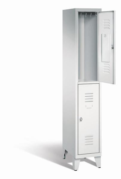 Ein lichtgrauer Garderobenschrank mit einem Abteil, zwei Fächern sowie integrierten Kleiderstangen mit Kleiderhaken, dessen obere Tür geöffnet ist. Er steht auf Stahlblechfüßen vor weißem Hintergrund.