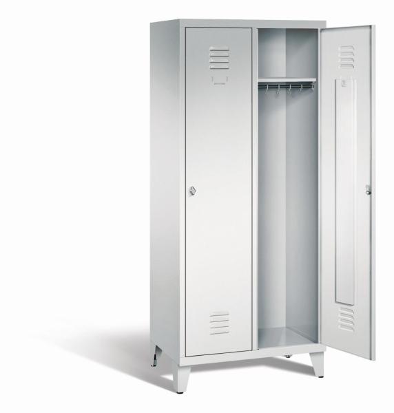 Ein lichtgrauer Garderobenschrank mit zwei Abteilen, zwei Fächern sowie integrierten Kleiderstangen mit Kleiderhaken, dessen rechte Tür geöffnet ist. Er steht auf Stahlblechfüßen vor weißem Hintergrund.