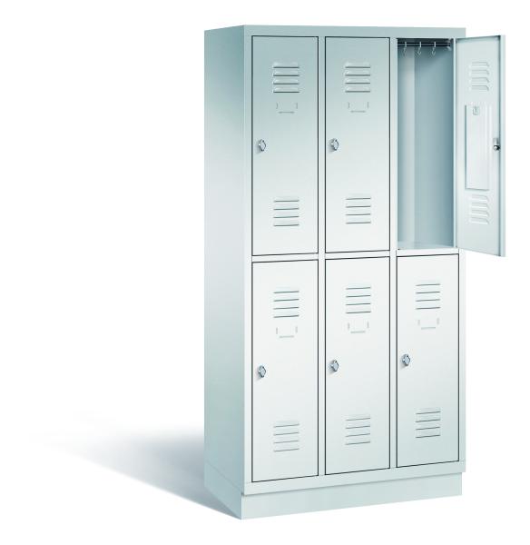 Ein lichtgrauer Garderobenschrank mit drei Abteilen, sechs Fächern sowie integrierten Kleiderstangen mit Kleiderhaken, dessen obere rechte Tür geöffnet ist. Er steht auf einem Stahlblechsockel vor weißem Hintergrund.