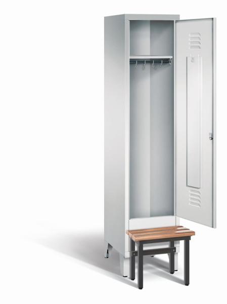 Ein lichtgrauer Garderobenschrank mit einem Abteil, einem Fach sowie integrierten Kleiderstangen mit Kleiderhaken, dessen Tür geöffnet ist. Er steht auf Stahlblechfüßen und hat eine vorgebaute Sitzbank vor weißem Hintergrund.