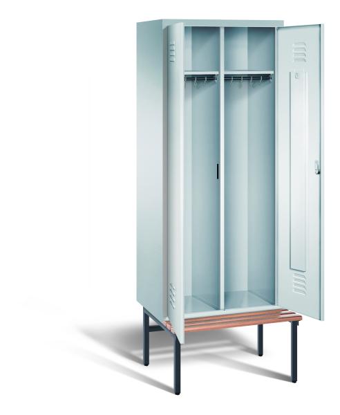 Ein lichtgrauer Garderobenschrank mit zwei Abteilen, zwei Fächern sowie integrierten Kleiderstangen mit Kleiderhaken, dessen Türen geöffnet sind. Er steht auf einer unter- und vorgebauten Sitzbank vor weißem Hintergrund.