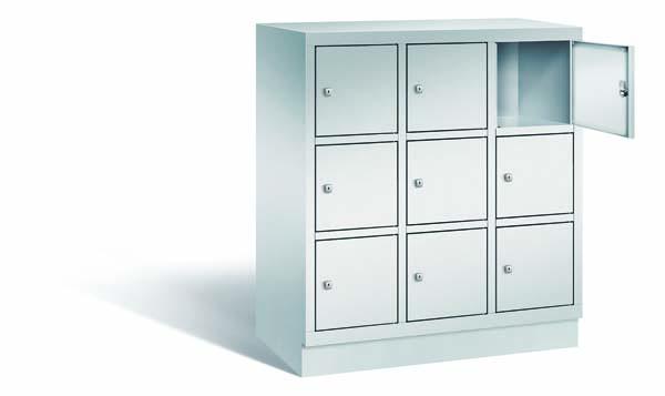 Lichtgrauer Fächerschrank mit drei Abteilen, neun Türen und neun Fächern, ideal zur Aufbewahrung von Gegenständen. Steht vor einem weißen Hintergrund.