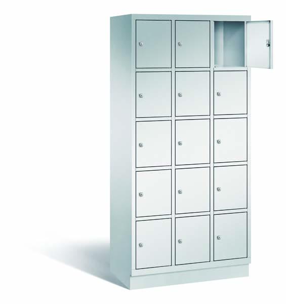 Ein lichtgrauer Fächerschrank mit drei Abteilen, 15 Türen und 15 Fächern, ideal zur Aufbewahrung von Gegenständen. Die obere rechte Tür ist geöffnet, während der Schrank vor einem weißen Hintergrund steht.
