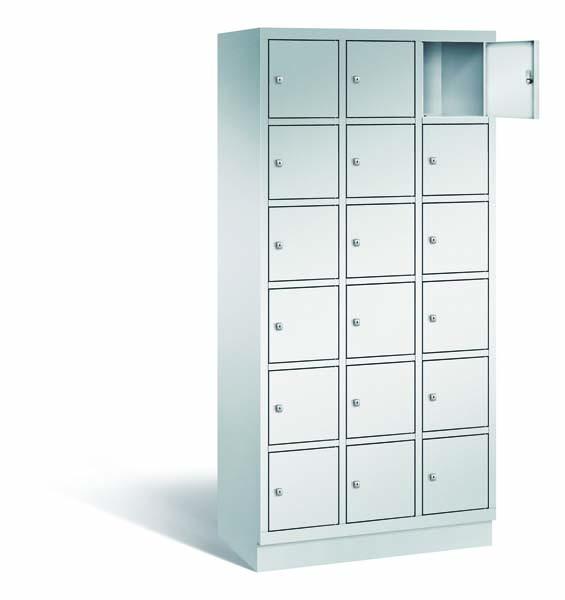 Ein lichtgrauer Fächerschrank mit drei Abteilen, 18 Türen und 18 Fächern, ideal zur Aufbewahrung von Gegenständen. Die obere rechte Tür ist geöffnet, während der Schrank vor einem weißen Hintergrund steht.