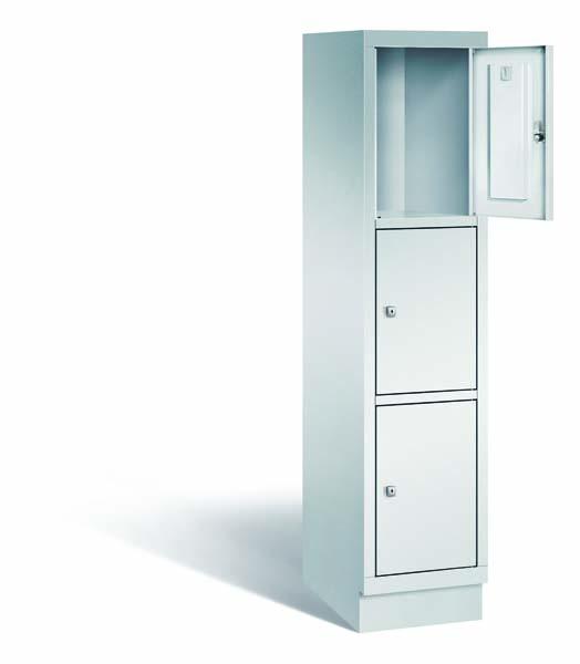 Ein lichtgrauer Fächerschrank mit einem Abteil, drei Türen und drei Fächern, ideal zur Aufbewahrung von Gegenständen. Die oberste der drei Türen steht offen und er steht vor einem weißen Hintergrund.