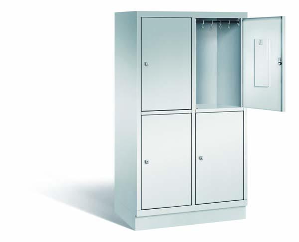 Ein lichtgrauer Fächerschrank mit zwei Abteilen, vier Türen und vier Fächern. Integrierte Kleiderstangen mit Kleiderhaken im Spind für praktische Aufbewahrung. Ideal zur Lagerung von Kleidung und anderen Gegenständen. Steht vor einem weißen Hintergrund.