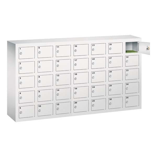 Lichtgrauer Handyfächerschrank mit 35 Fächern mit Zylinderschloss und Nummerierung, wovon das oberste Fach geöffnet ist. Der Schrank steht vor einem weißem Hintergrund.