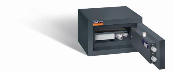 Ein graphitgrauer Möbeltresor mit einer geöffneten Tür. Im Innenraum befindet sich eine Kassenbox, ein Laptop und zwei Baupläne. Das Produkt steht vor einem weißen Hintergrund.