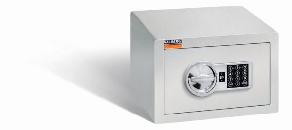 Ein lichtgrauer Möbeltresor mit einem elektronischen Schloss. Die Tür ist geschlossen. Der Tresor steht vor einem weißen Hintergrund.