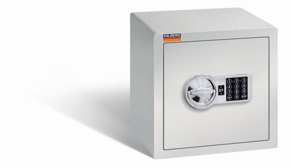 Ein lichtgrauer Möbeltresor mit einem elektronischen Schloss. Die Tür ist geschlossen. Der Tresor steht vor einem weißen Hintergrund.