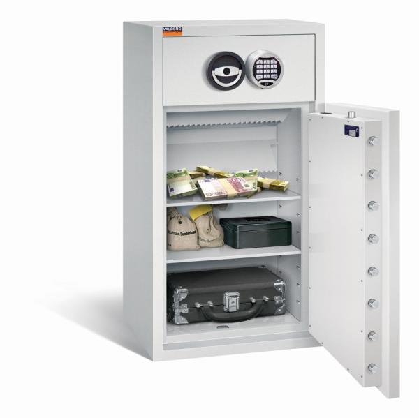 Ein lichtgrauer Deposittresor mit sichtbarer Türverriegelung. Im Innenraum befinden sich zwei Fachböden mit Geld, Geldbeuteln, einer Kassenbox und einem Aktenkoffer. Das Produkt steht vor einem weißen Hintergrund.