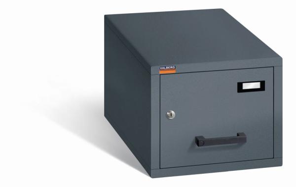 Geschlossener Graphitgrauer Aktenlagerschrank mit Doppelbart-Sicherheitsschloss.  Die Schublade ist mit gummiummantelten Plastikgriffen und Etikettenhaltern ausgestattet. Der Tresor steht vor einem weißen Hintergrund.