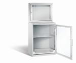 Lichtgrauer Computerschrank mit abschließbarem Sichtfenster im oberen Bereich und geöffneter Acrylglas-Stahltür im unteren Bereich und einem höhenverstellbarer Fachboden sowie Auszugsboden. Der Schrank steht vor weißem Hintergrund.