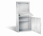 Lichtgrauer Computerschrank mit abschließbarem Sichtfenster im oberen Bereich und geöffneter Stahltür mit zwei Schubladen im unteren Bereich und einem höhenverstellbarer Fachboden. Der Schrank steht vor weißem Hintergrund.